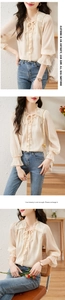 Detail of ruffle collar and tie design on beige chiffon blouse with lantern sleeves