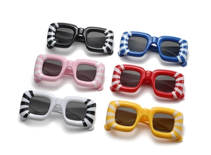 Flat lay of vintage thick-frame sunglasses in six colors with bold striped textures