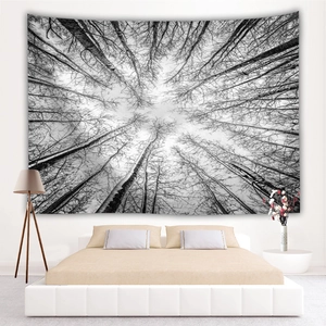 Modern black and white forest tapestry hanging on a bedroom wall in a minimalist style