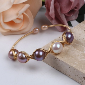 Detailed shot of handmade woven 14K gold-filled wire cuff featuring five large natural pearls