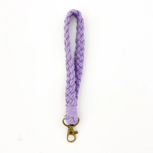 Detailed close-up of handmade purple braided cotton phone strap with bronze metal lobster clasp