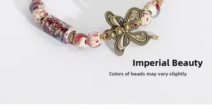 Macro detail of ceramic beads and bronze butterfly pendant on woven ethnic bracelet