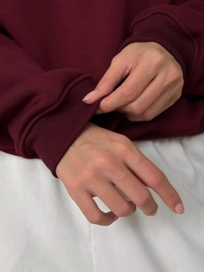 Detailed view of the elastic ribbed cuffs on a thick burgundy polo fleece sweatshirt
