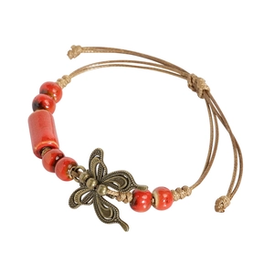 Ethnic ceramic bracelet with red beads and bronze butterfly charm on braided cord