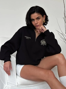 Detailed view of the half-zip collar and college style chest print on this black hoodie