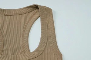 Gros plan sur la texture en maille côtelée et les coutures de qualité d'un crop top kaki