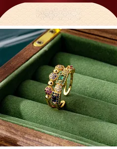 Detailed shot of gold-plated geometric ring with colorful zircons in green velvet box