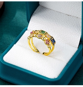 Macro detail of gold-plated ring with colorful gemstones and crystals in a jewelry box