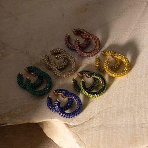 Set of 18K gold plated C-shaped earrings with colorful zirconia stones on a stone base