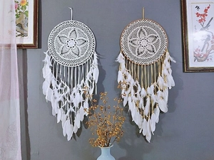 Close-up of bohemian white feathers and beaded tassels on large dreamcatchers