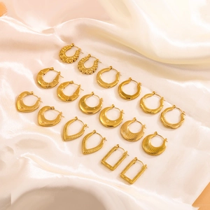 Golden geometric stainless steel earring set with assorted vintage designs on silk