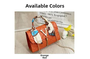 Detail of orange quilted crossbody bag with silk scarf handle and V-logo fringe