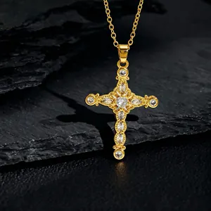 Macro shot of gold cross pendant necklace with white zircons on dark stone base