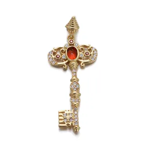 Close-up of golden vintage key pendant with red zircon and sparkling white stones