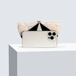 Detail view of acrylic evening bag with marble texture and phone for size reference
