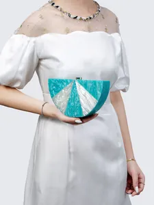 Detail view of semi-circular marble acrylic clutch with glitter finish and gold lock