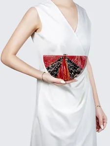 Detail of red and black marble acrylic semicircular clutch bag with gold clasp