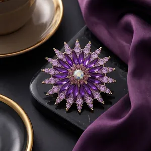 Exquisite purple crystal sunflower brooch with gold setting on black marble display