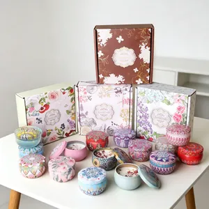 Close-up of bohemian style scented soy candles in tin cans with floral gift packaging