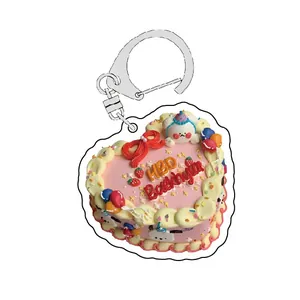 Detail of heart-shaped acrylic birthday cake keychain with cute bunny and pink cream decor