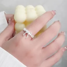Close-up of zircon hollow butterfly ring with silver finish on a model's hand