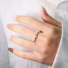 Detailed view of silver double-layered meteor ring with sparkling zircon stones on finger