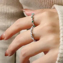Macro detail of silver geometric rings with green gemstone and sparkling pavé crystals