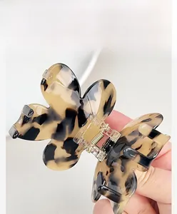 Detailed close-up of a floral acetate hair claw clip with a tortoiseshell pattern finish