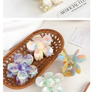 Detail view of colorful acetate flower claw clips with marble texture in a woven basket
