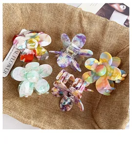 Close-up of five floral acetate hair claws with marble texture and strong metal springs