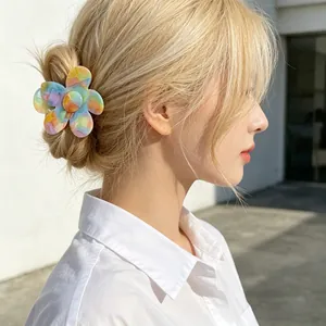Floral acetate hair claw clip with colorful floral design worn on a stylish updo