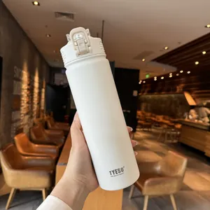 Close-up of off-white stainless steel vacuum flask with straw and flip-top lid