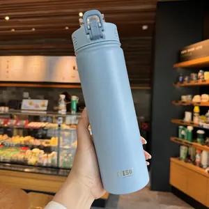 Close-up of matte light blue insulated bottle with a sturdy handle for outdoor use