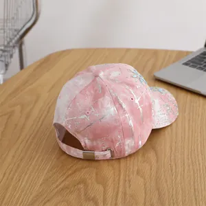 Detailed close-up of pink marble tie-dye baseball cap with sparkling rhinestone flowers