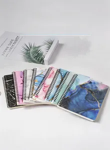 Detail showing seven A5 spiral notebooks with artistic marble and starry sky cover patterns