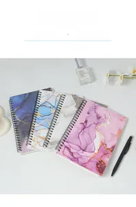 Detail view of A5 spiral notebooks with marble and watercolor art style covers