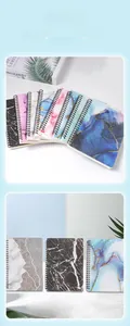 Detailed close-up of A5 spiral notebooks with marble and watercolor cover designs