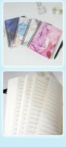 Detail of A5 spiral notebooks with marble textures and lined pages for writing