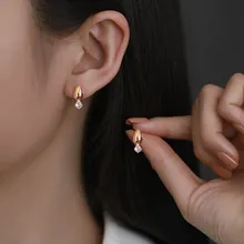 Orecchini a goccia in oro rosa con zircone quadrato indossati per mostrare i dettagli