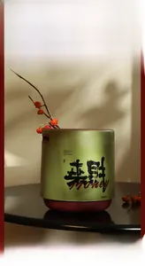 Macro shot of 12L green luxury waste bin with handle and golden Chinese calligraphy