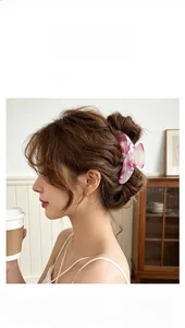 Pink marble texture resin hair claw clip shown in a side-view hairstyle detail