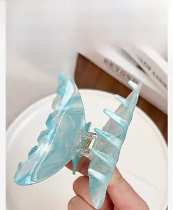 Detail of blue marble texture butterfly hair claw clip with a strong metal spring