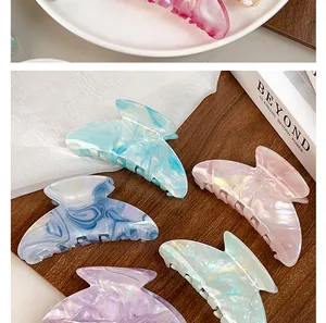 Detailed close-up of butterfly-shaped acetate hair claws in various marble textures