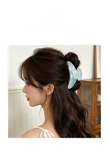 Detail view of large marble texture hair claw clip worn on model with long hair