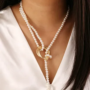 Elegant multi-layer pearl necklace with golden metal ring clasps on silk fabric
