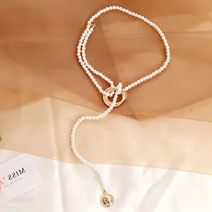 Macro view of vintage pearl necklace with golden portrait coin pendant and chain detail