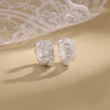 Close-up of silver hoop earrings with sparkling micro-pave zircons on a lace background