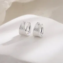 Detailed view of silver U-shaped clip earrings with a unique brushed bark texture finish