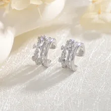 Close-up of double-layered silver ear cuffs with sparkling zirconia and crown design
