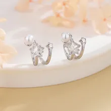 Macro shot of silver metal ear cuffs with double stars and elegant white pearls